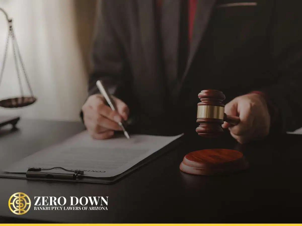 An Arizona bankruptcy lawyer writes at a desk with a gavel and scales, symbolizing legal work