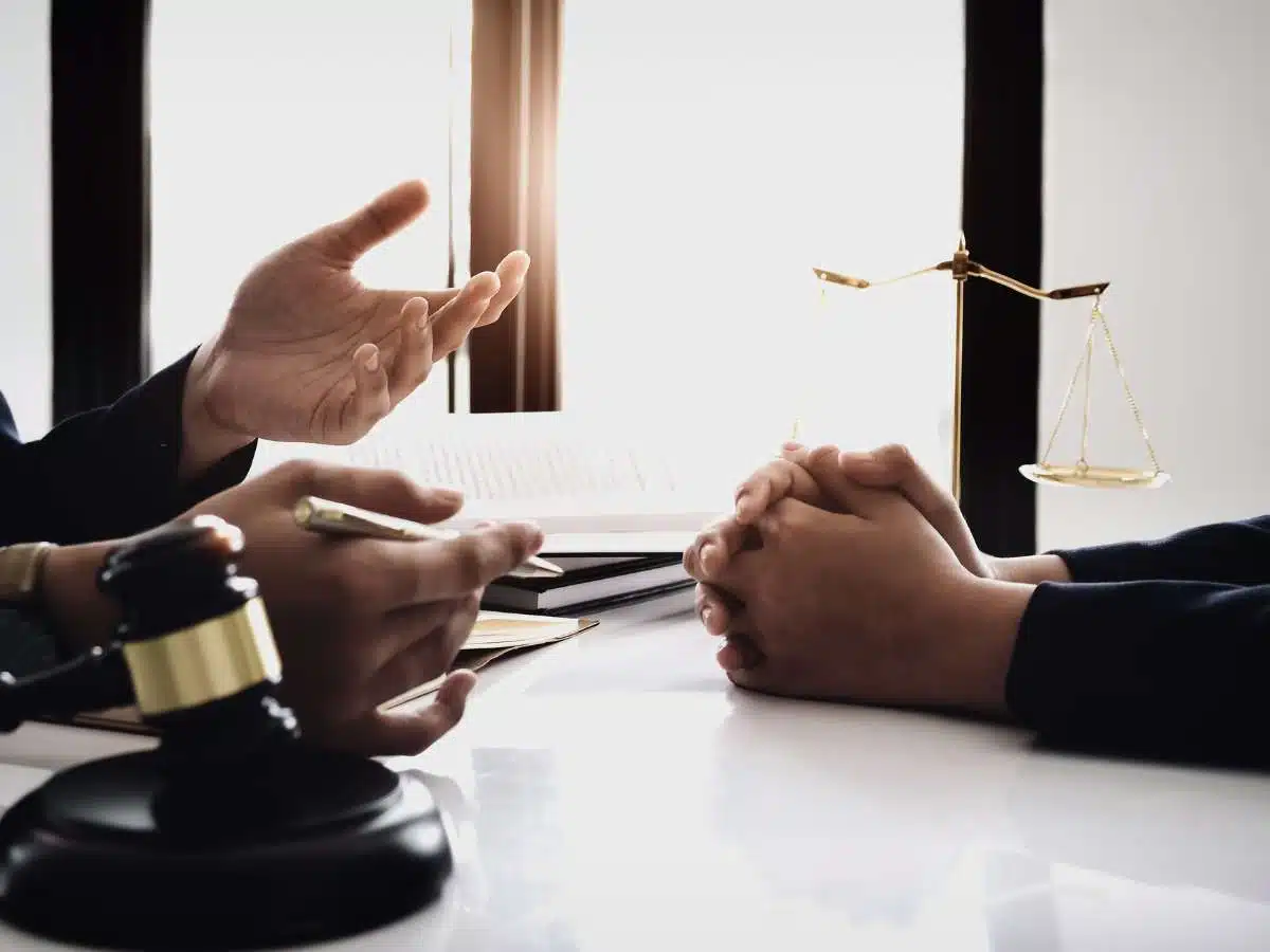 Hands and gavel on a desk during a legal consultation with scales of justice in the background, discussing Bankruptcy Filing